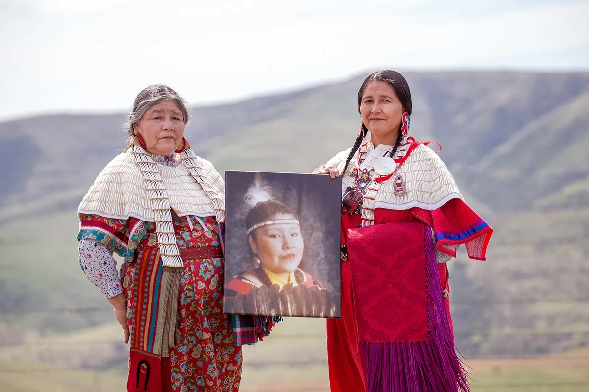 Mildred Quaempts and Merle Kirk hold a portrait of Mavis Kirk-Greeley